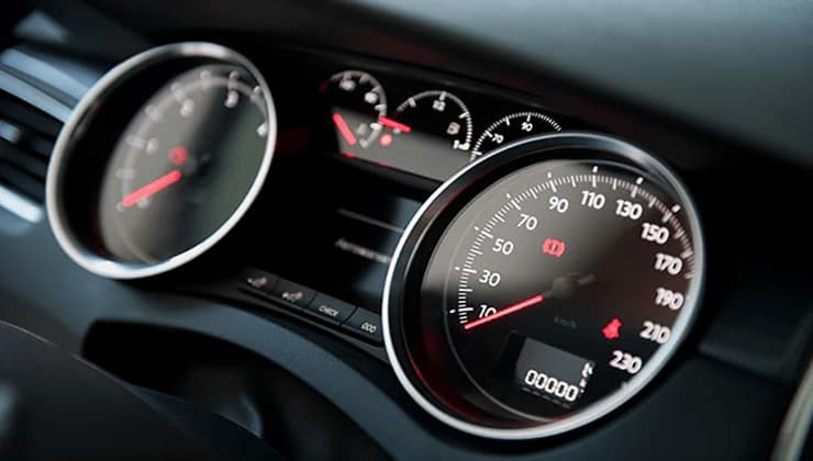 Close-up of a car dashboard displaying the speedometer and instrument gauges. Close-up of a car dashboard displaying the speedometer and instrument gauges.