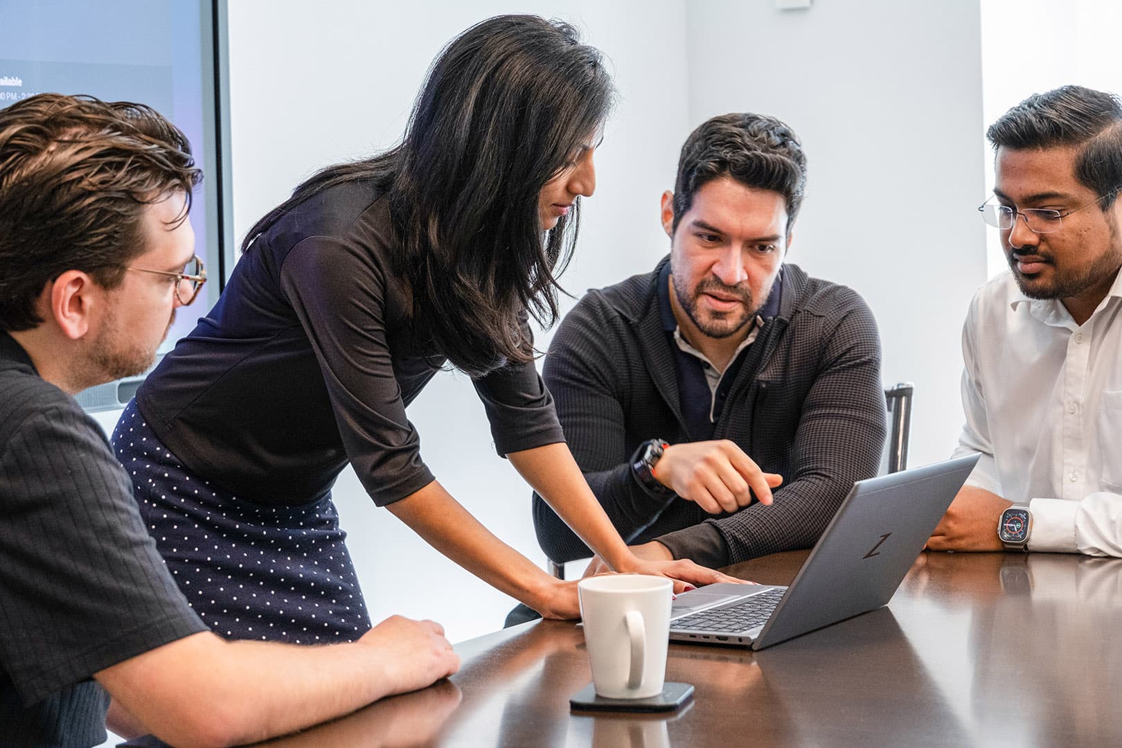 Two coworkers gathered around a laptop in a meeting room, collaborating on a project. Two coworkers gathered around a laptop in a meeting room, collaborating on a project.
