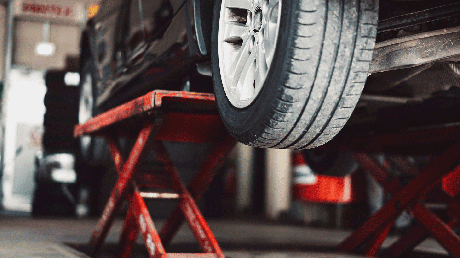 Vehicle raised on a service lift in an auto repair shop for commercial fleet maintenance and repair. Vehicle raised on a service lift in an auto repair shop for commercial fleet maintenance and repair.