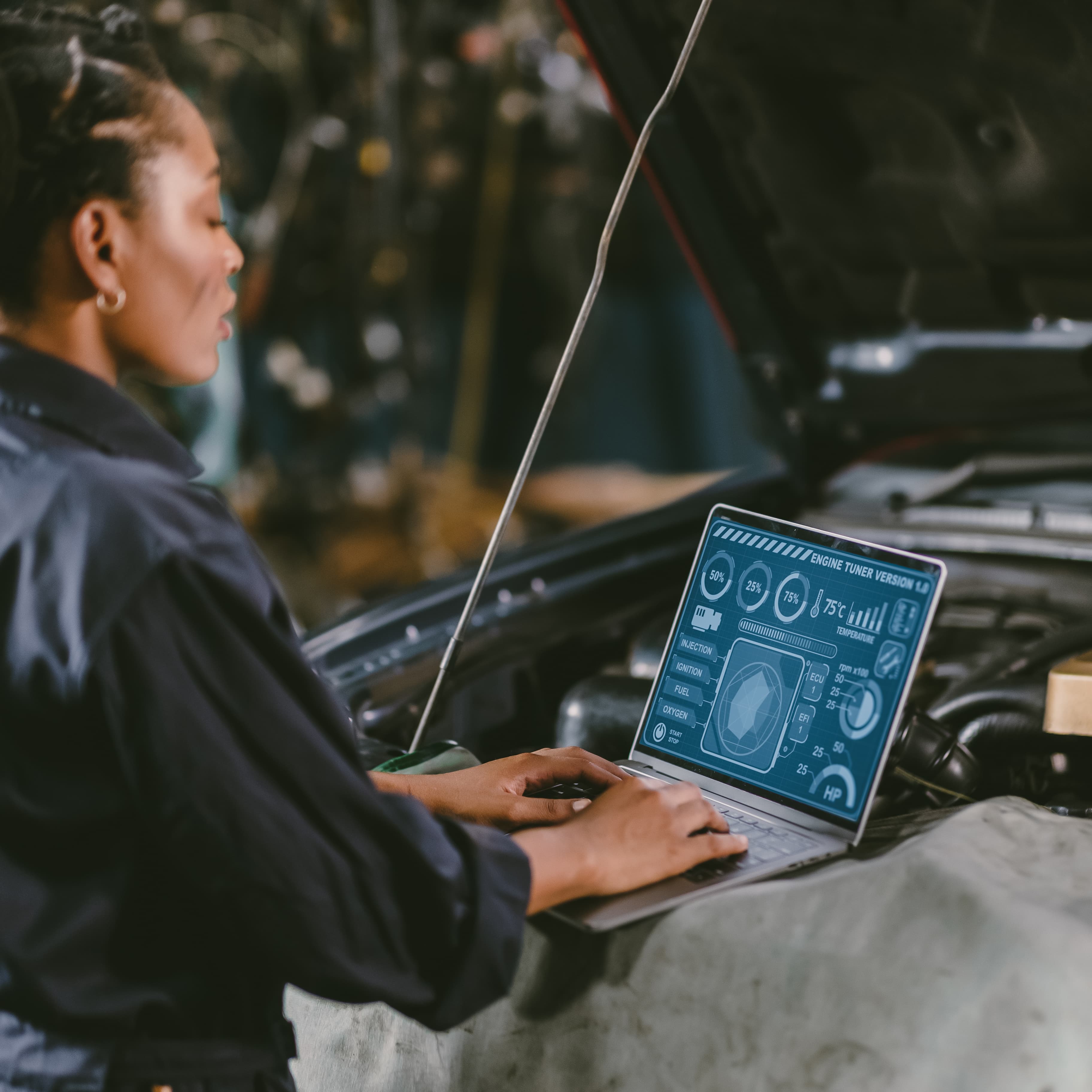 A female auto mechanic inspecting and working on a car engine in a garage. A female auto mechanic inspecting and working on a car engine in a garage.