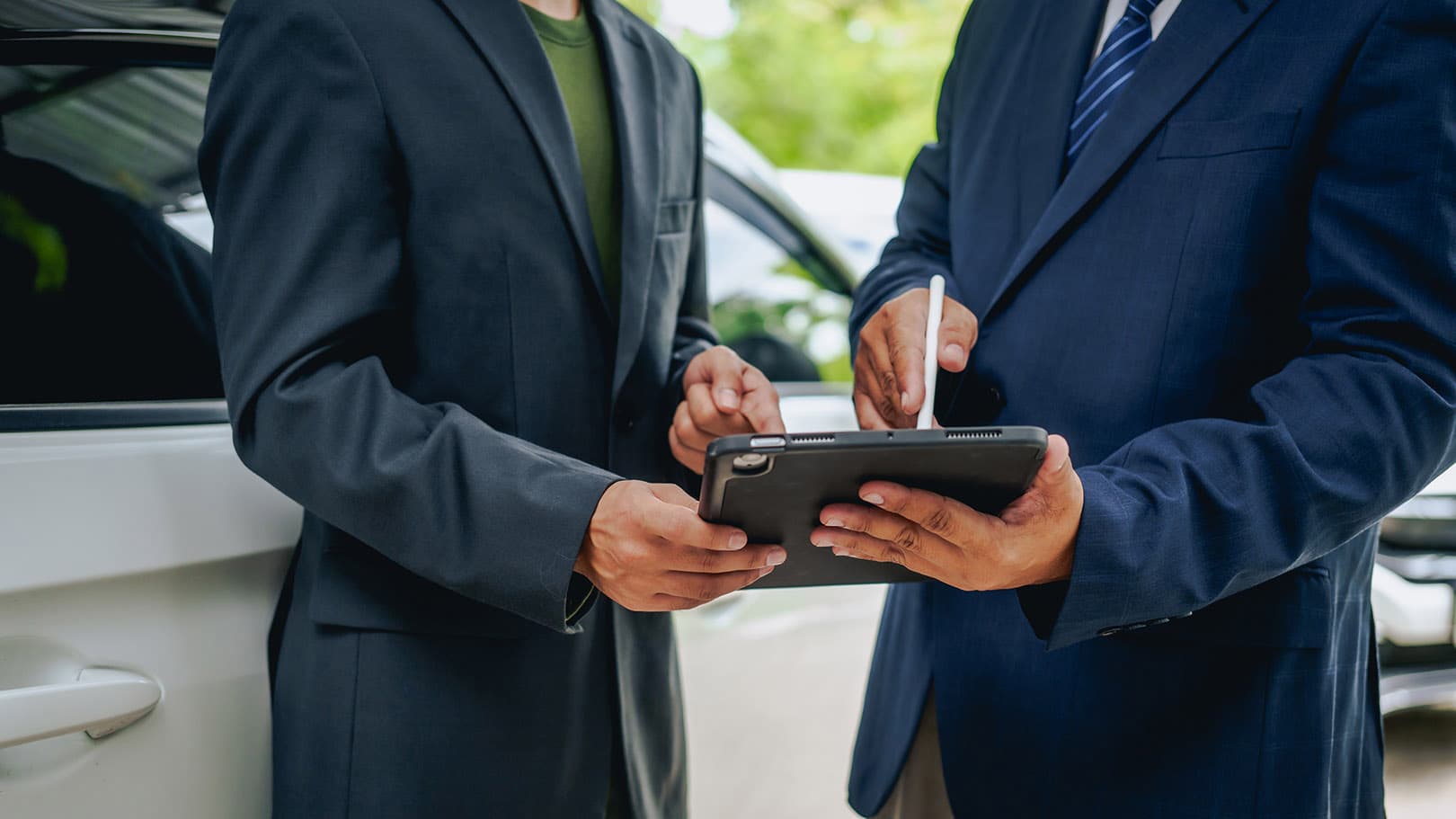 A car insurance agent discussing coverage options with a client. A car insurance agent discussing coverage options with a client.